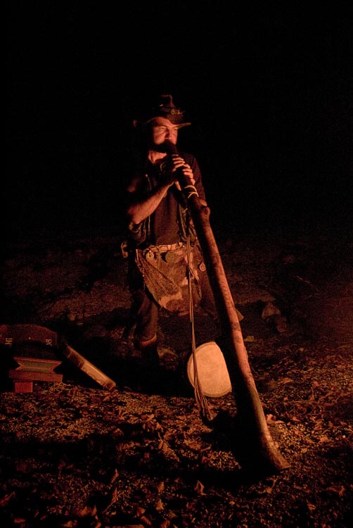Didgeridoospieler in urigem Ledergewand mit Fell im Feuerschein