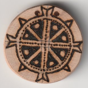 Mit Brennglas und Sonne bebrannte Holzscheibe mit Mutter Erde Symbol
