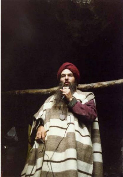 Mann mit langen Bart und Turban und Mikrofon in der Hand