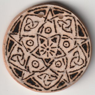 Sonnengebranntes Amulett auf Holzscheibe mit Pentagramm und keltischen Knoten
