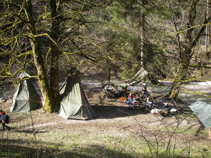 Zelte und Planen an einem wildromantischen Platz an einem Bergbach