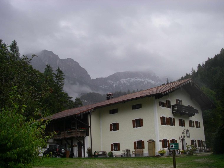 Alter Berggasthof zu Füßen eines Felsgebirges