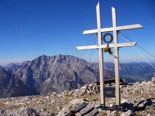 Sehr spezielles Gipfelkreuz aus doppelten Balken mit markanten Felsberg im Hintergrund