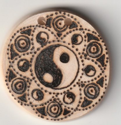 Sonnenbebrannte Holzscheibe mit Yin & Yang in Lebensblume