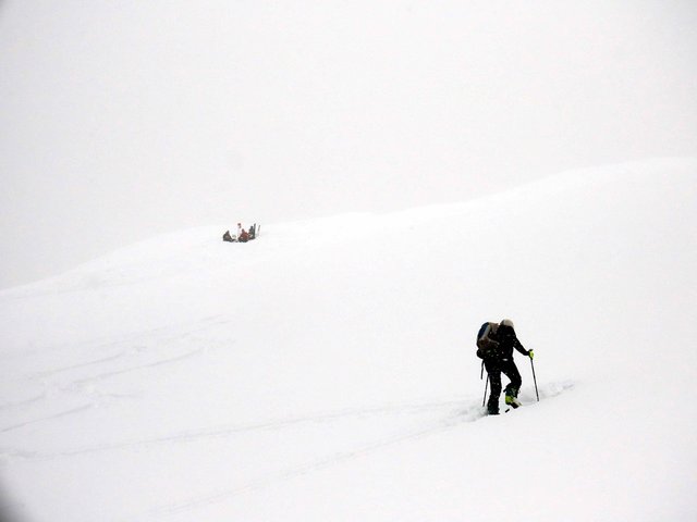 Skibergsteiger auf den letzten Metern zum Gipfel wo bereits weitere Skibergsteiger warten
