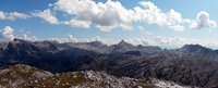 Blick von einem hohen Gipfel auf eine wilde, einsame Bergwelt
