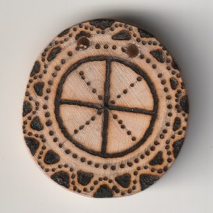 Mit Brennglas und Sonne bebrannte Holzscheibe mit Mutter Erde Kreuz Symbol