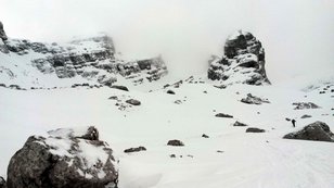 Wilde hochalpine Landschaft mit Schnee, Felsen und Wolken