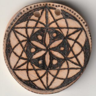 Sonnenbebrannte Holzscheibe mit Hexagon in einer Blume des Lebens