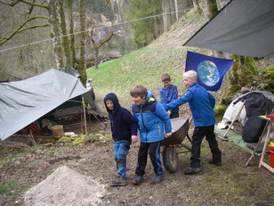 Kinder mit Schubkarren zwischen Planen und Zelten 