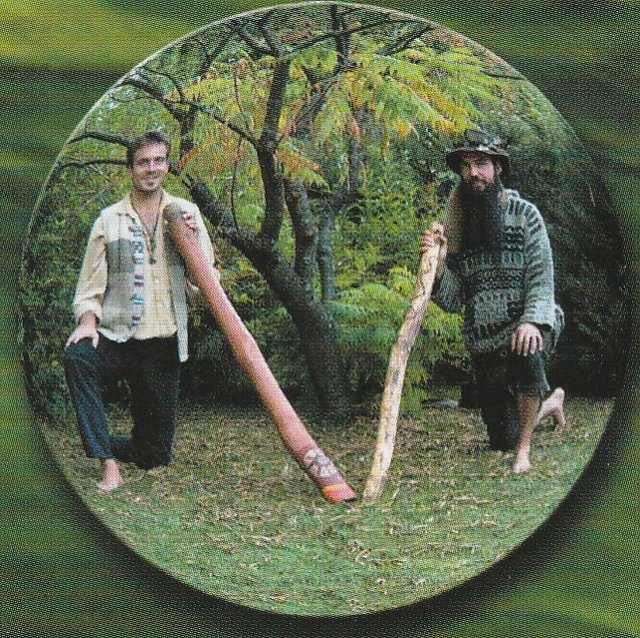 Zwei Musiker mit Didgeridoos in einer Glaskugel