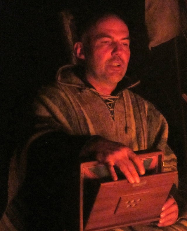 Musiker mit Srutibox im Feuerschein