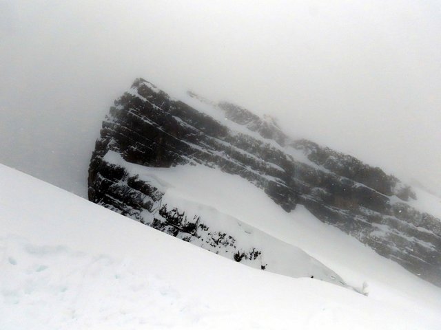 Winterlicher Berggipfel mit markanten, diagonalen Felsplatten